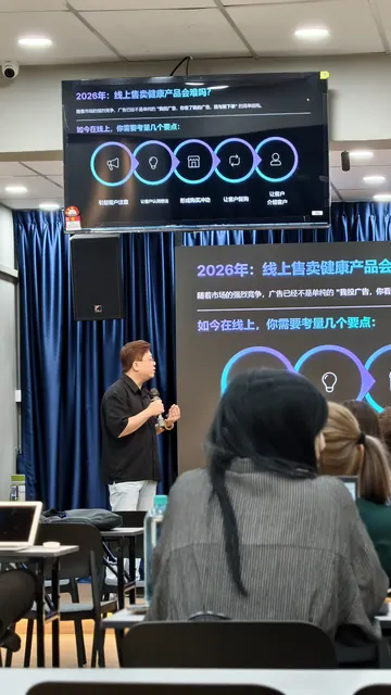Trainer presenting to an audience with slides on a large screen